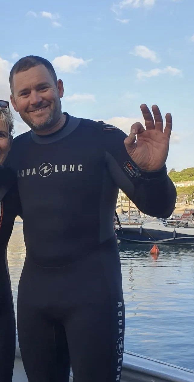 Mark in a wetsuit giving the OK sign