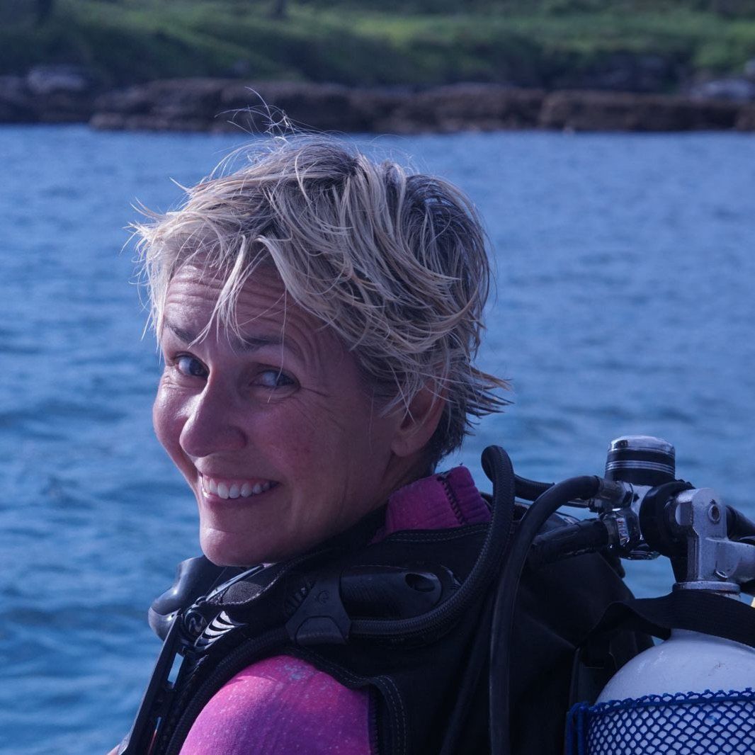 Mim smiling on a boat, sea behind her